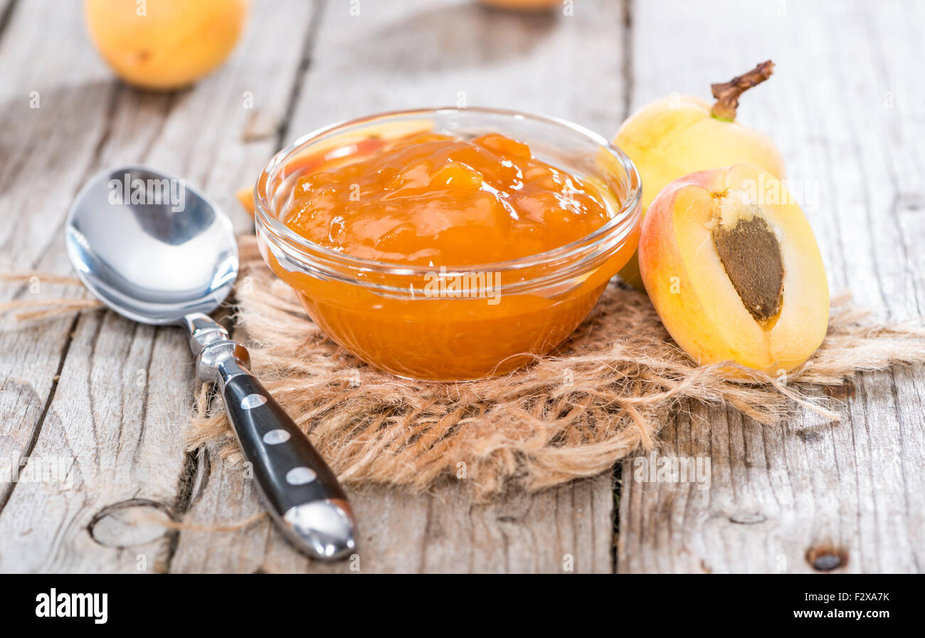 Porzione di marmellata di albicocche fatta in casa su sfondo di legno Foto Stock