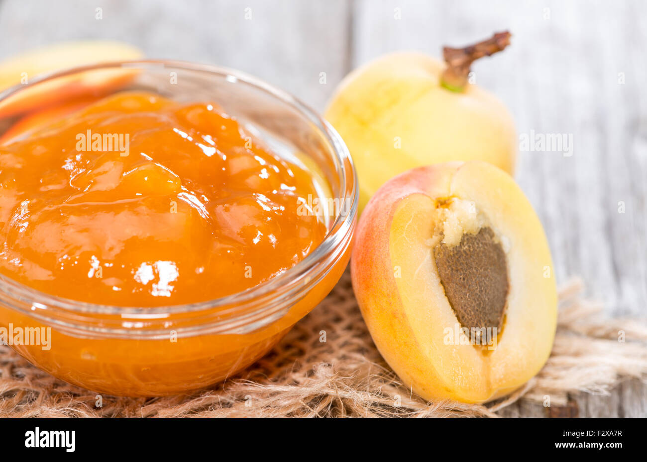 Porzione di marmellata di albicocche fatta in casa su sfondo di legno Foto Stock
