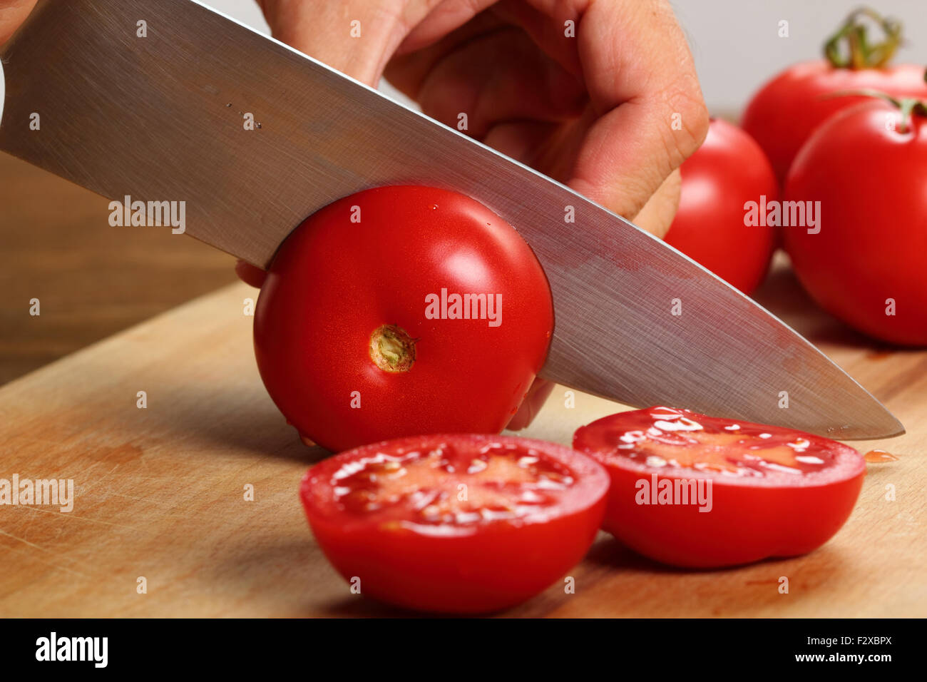 Affettare i pomodori a metà Foto Stock