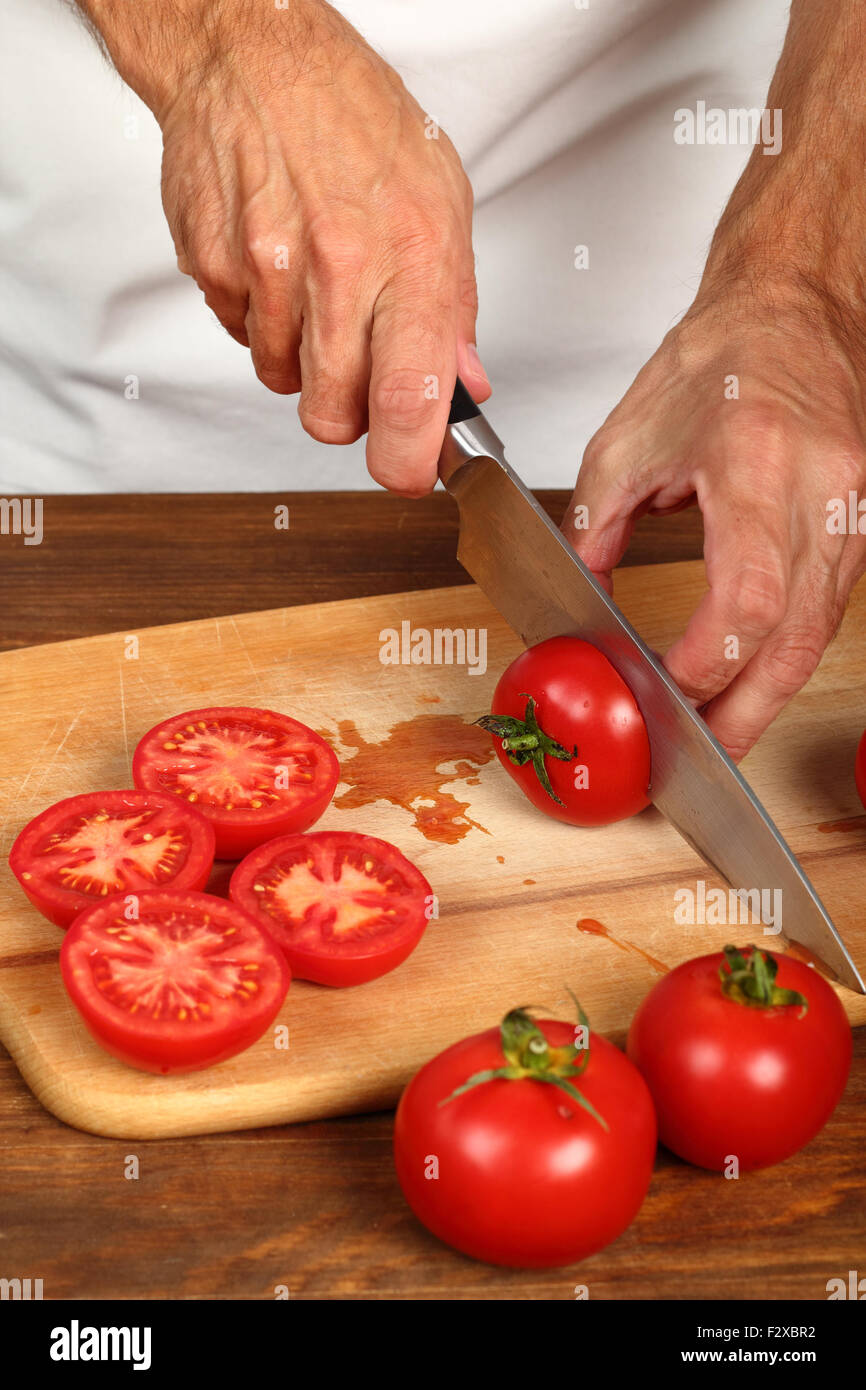 Affettare i pomodori a metà Foto Stock