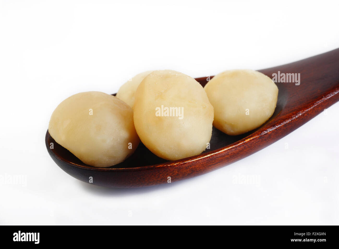 Noci di macadamia sul cucchiaio di legno Foto Stock