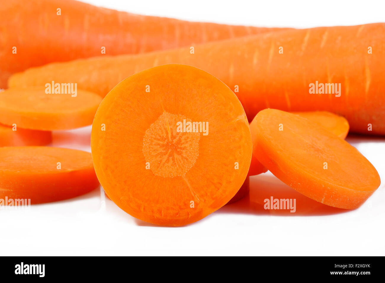 Freschi carote tagliate a fette su sfondo bianco Foto Stock