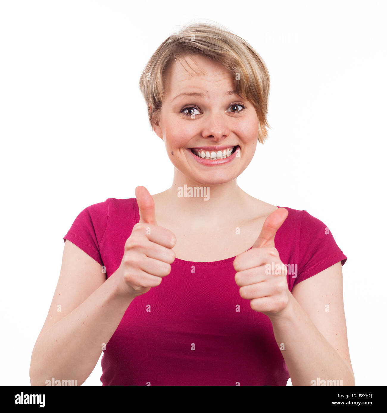 Giovane donna che mostra il suo pollice in alto in un atteggiamento positivo, isolato su bianco Foto Stock