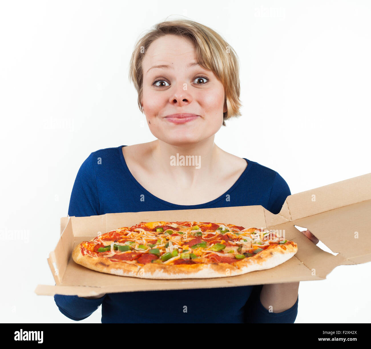 Giovane donna tenendo una pizza dal fast food e sorridente, isolato su bianco Foto Stock