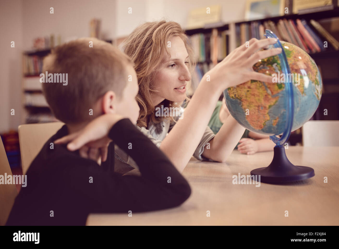 Istruzione e divertimento. I bambini con insegnante i giochi in uno scenario in aula. Ritratto di giovane di bambini in aula, giocando e ed Foto Stock