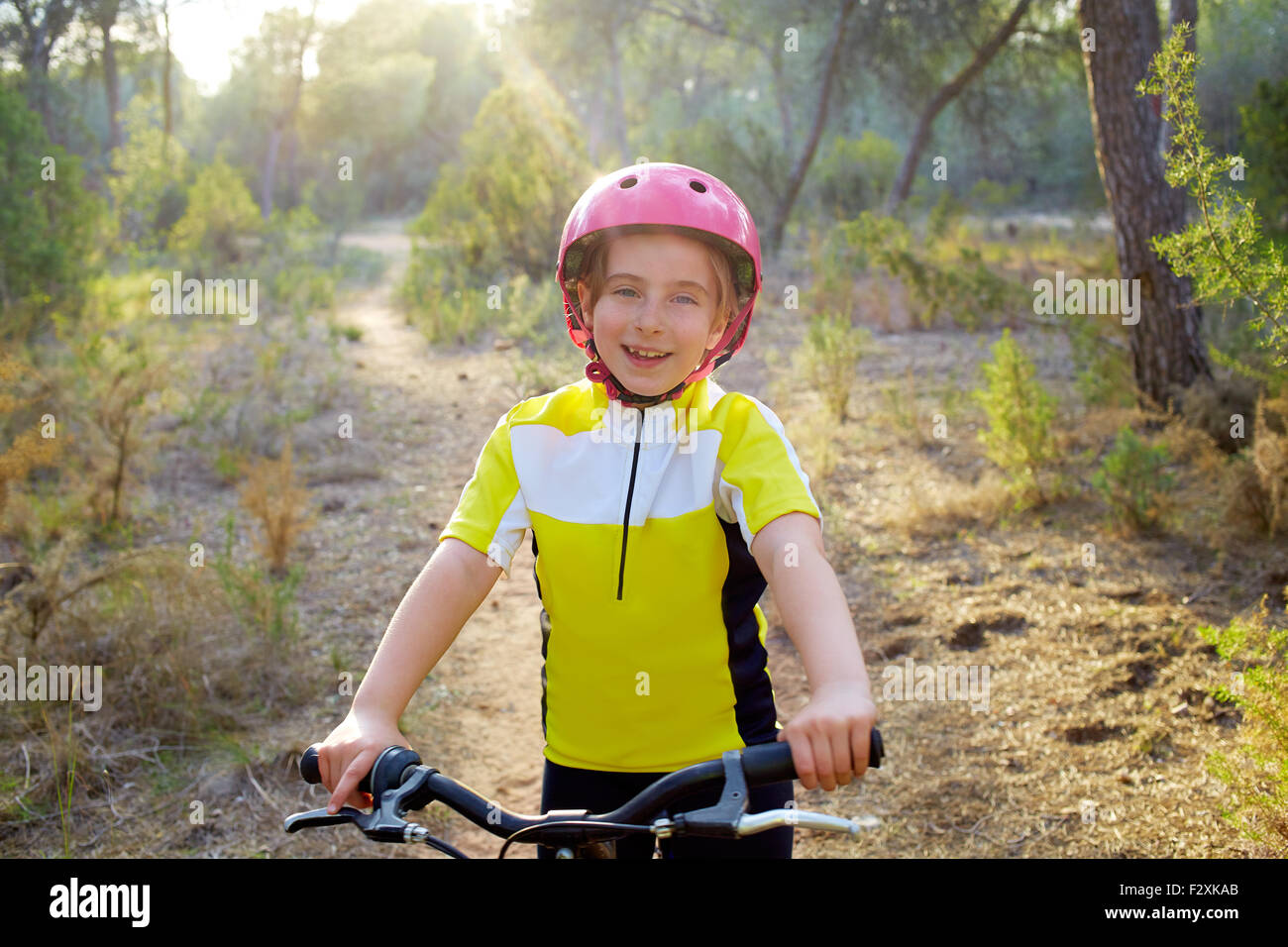 Kid ragazza biker in mountain bike mtb presso la foresta mediterranea Foto Stock