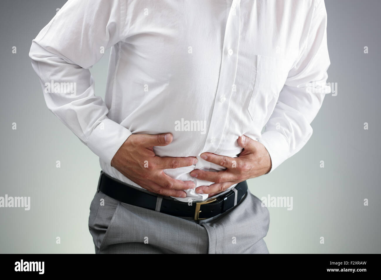 Imprenditore tenendo il suo stomaco nel dolore con stomachache o indigestione Foto Stock