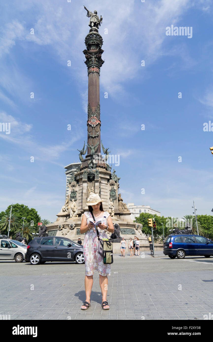 Turistico con libro guida vicino a Mirador de Colón Columbus Statua in Placa del Portal de la Pau Barcellona Spagna Foto Stock