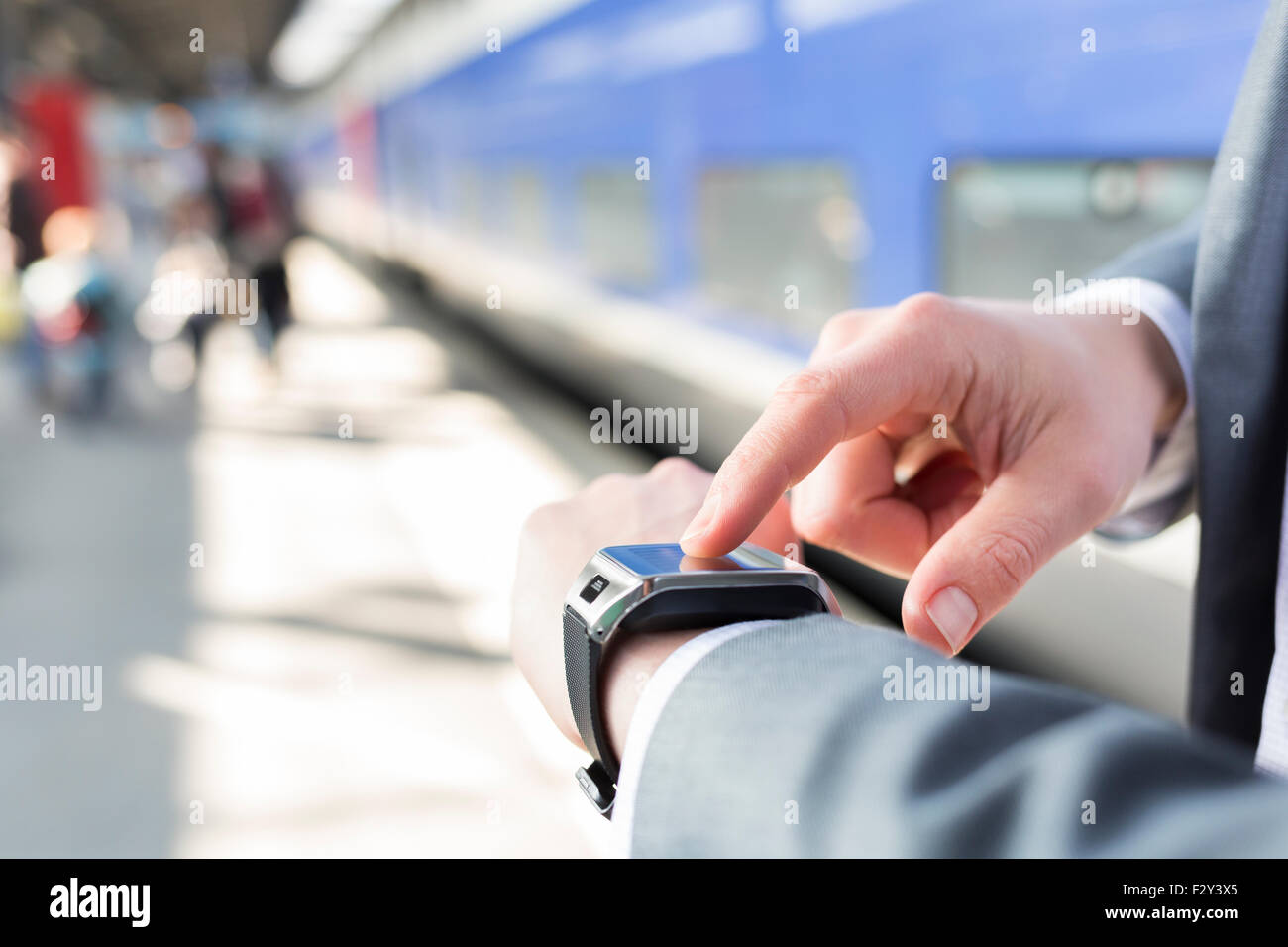Sulla piattaforma della stazione di un uomo con il suo smartwatch. Close-up le mani Foto Stock Sulla piattaforma della stazione di un uomo con il suo smartwatch. Close-up le mani Foto Stock