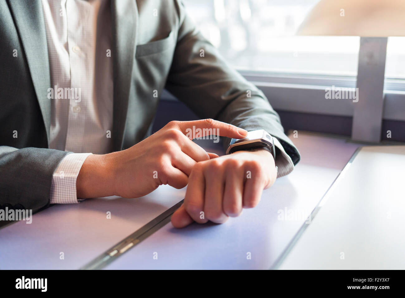 In treno un uomo con il suo smartwatch. Close-up le mani Foto Stock In treno un uomo con il suo smartwatch. Close-up le mani Foto Stock