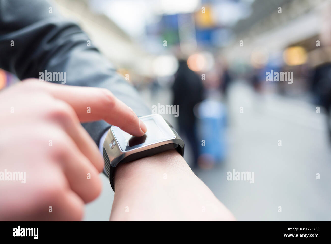 Nella postazione di sala di un uomo con il suo smartwatch. Close-up le mani Foto Stock