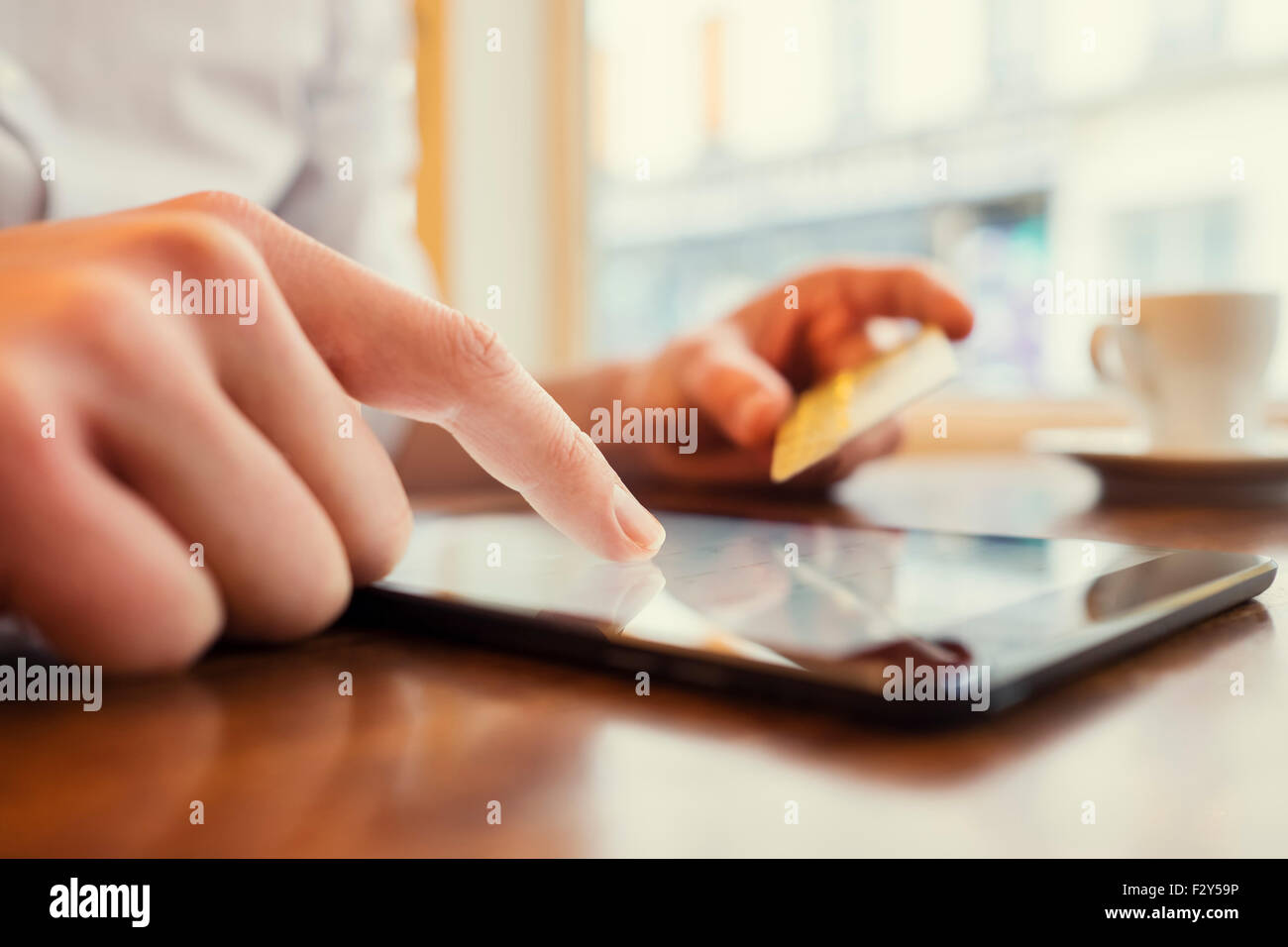 Uomo che utilizza un Tablet PC. Carta di credito, shopping online. Sfondo finestra Foto Stock