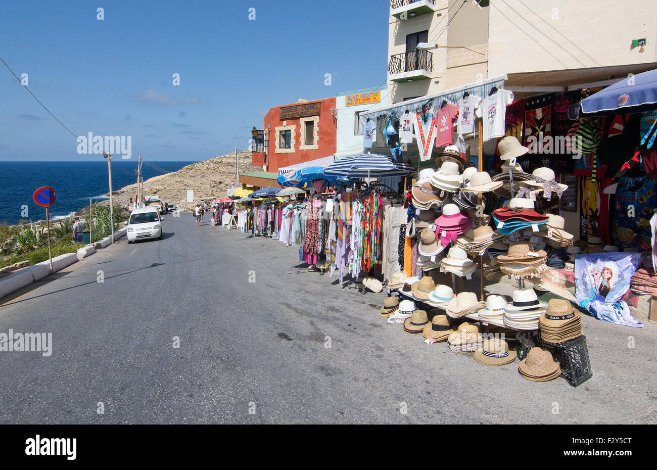 Gabbie di souvenir e ristoranti fiancheggiano la strada vicino alla famosa attrazione turistica di Blue Grotto, Malta. Foto Stock