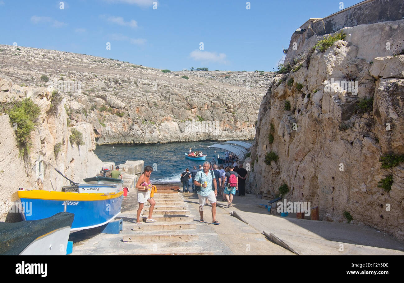 Lasciare turistica molo e le barche sono collocati lungo la ripida strada del popolare attrazione turistica di Blue Grotto di Malta. Foto Stock