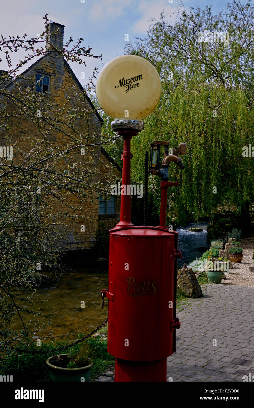 Vecchio spirito pompa. Cottage gable end, stream e albero in background. Foto Stock