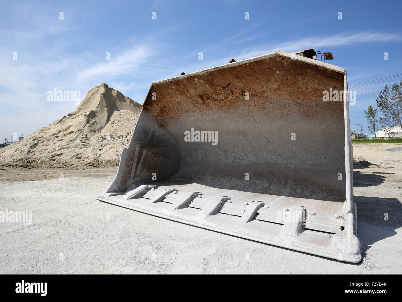 Sabbia e ghiaia tumulo con bulldozer contro il cielo blu Foto Stock