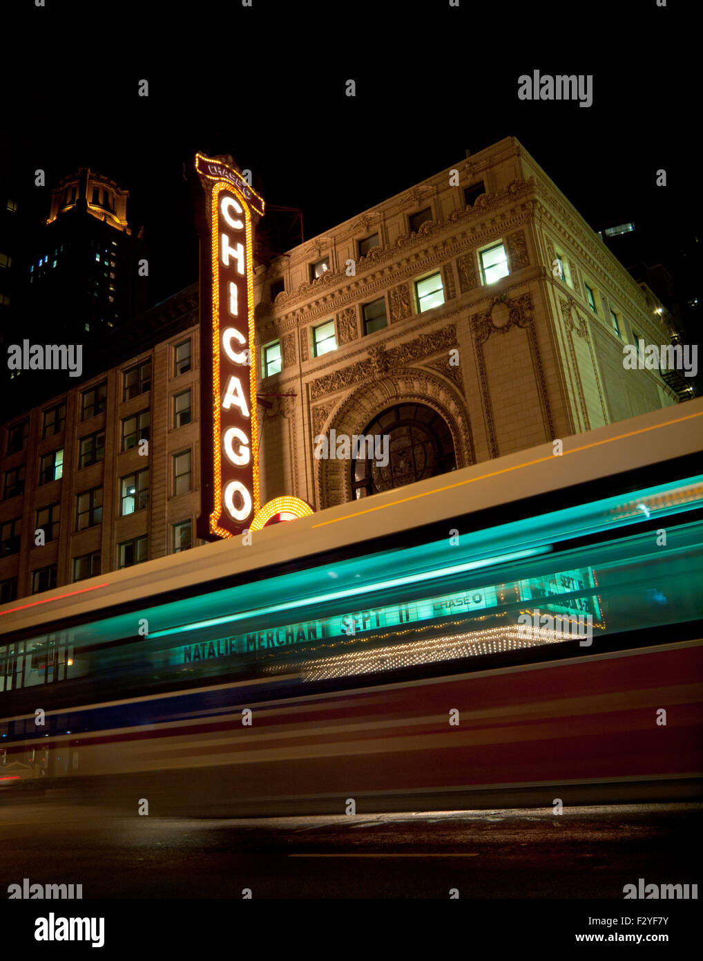 A Chicago Transit Authority (CTA) bus striature dal Chicago Theatre di notte. Foto Stock