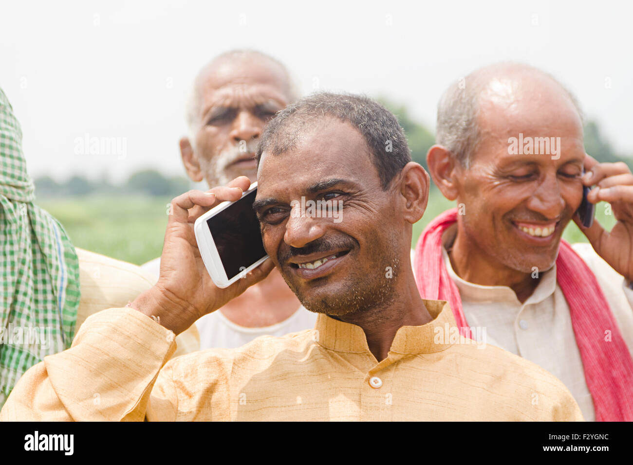 4 rurale indiano maso contadino parlando del telefono mobile Foto Stock