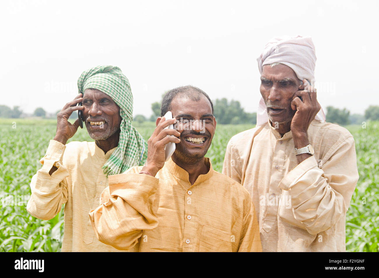 3 rurale indiano maso contadino parlando del telefono mobile Foto Stock