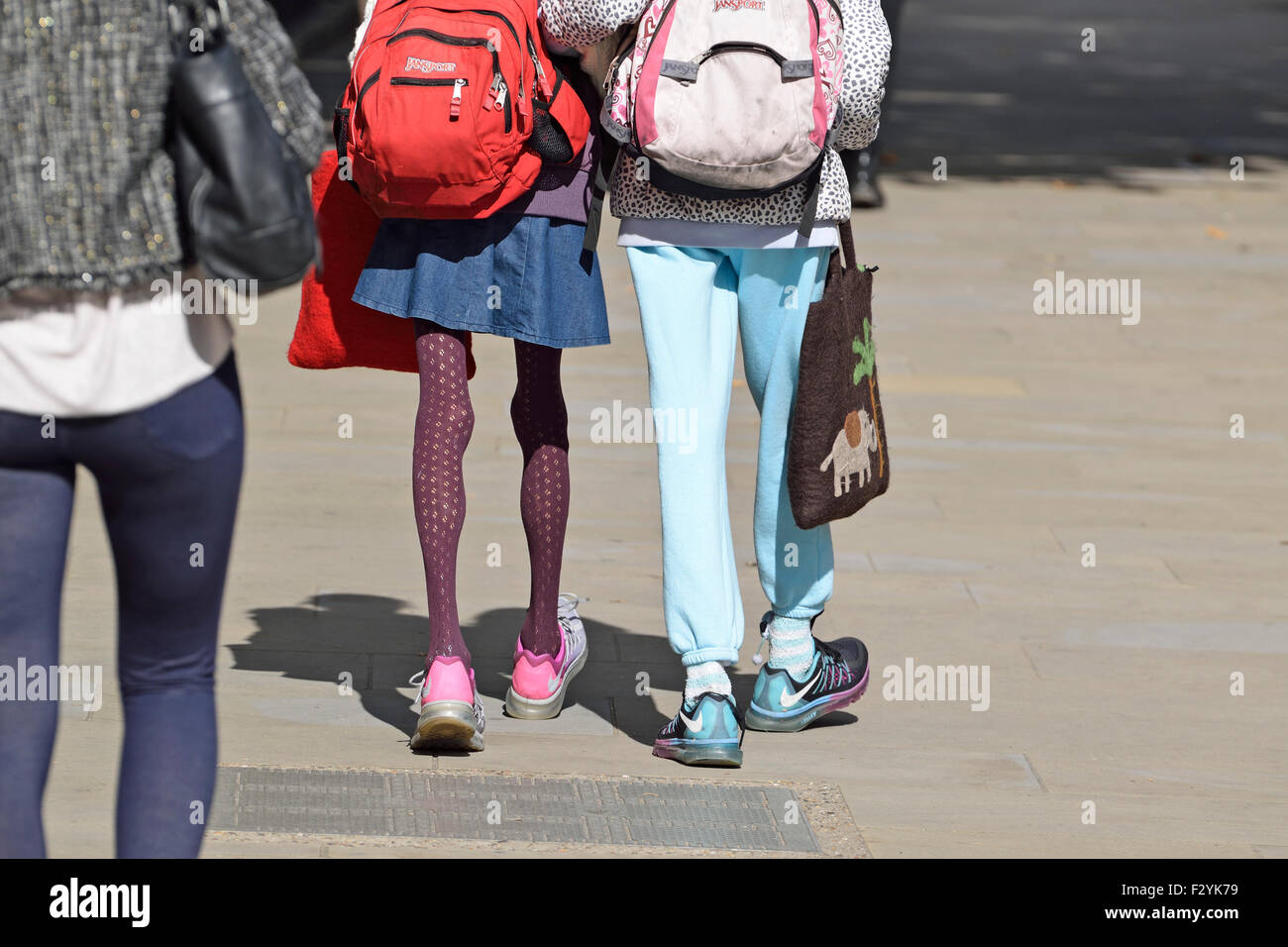 Londra, Inghilterra, Regno Unito. Donna con molto sottili gambe camminando con un amico Foto Stock