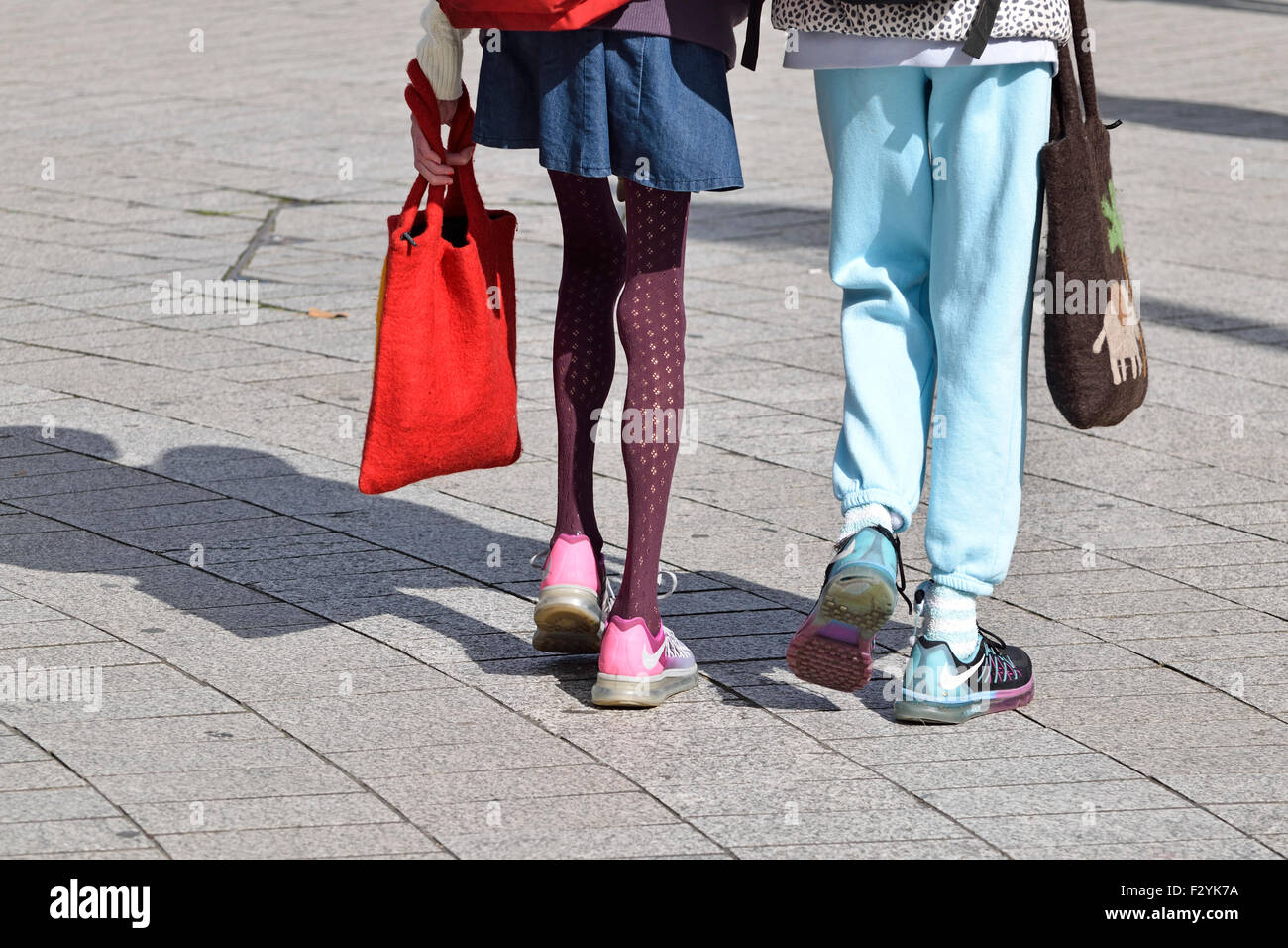 Londra, Inghilterra, Regno Unito. Donna con molto sottili gambe camminando con un amico Foto Stock