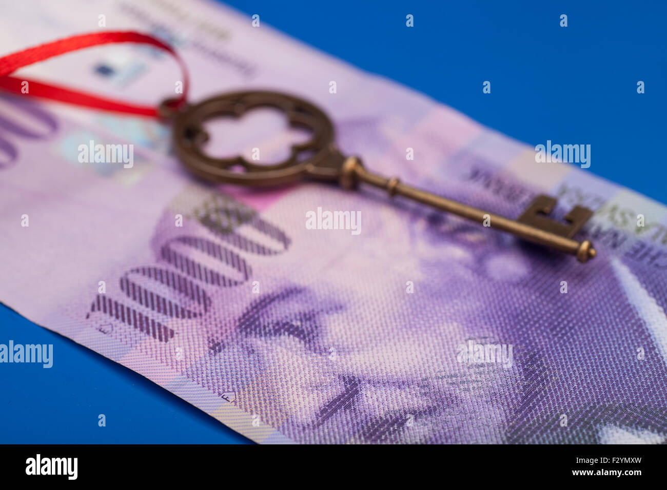 La chiave del successo con fiocco rosso su 1000 Franco svizzero nota su blu Foto Stock