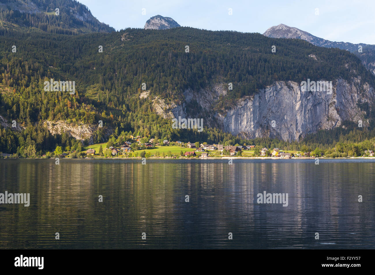 Gli edifici e le montagne in Grundlsee, Austria durante l'estate. Parte del lago può essere visto. Foto Stock