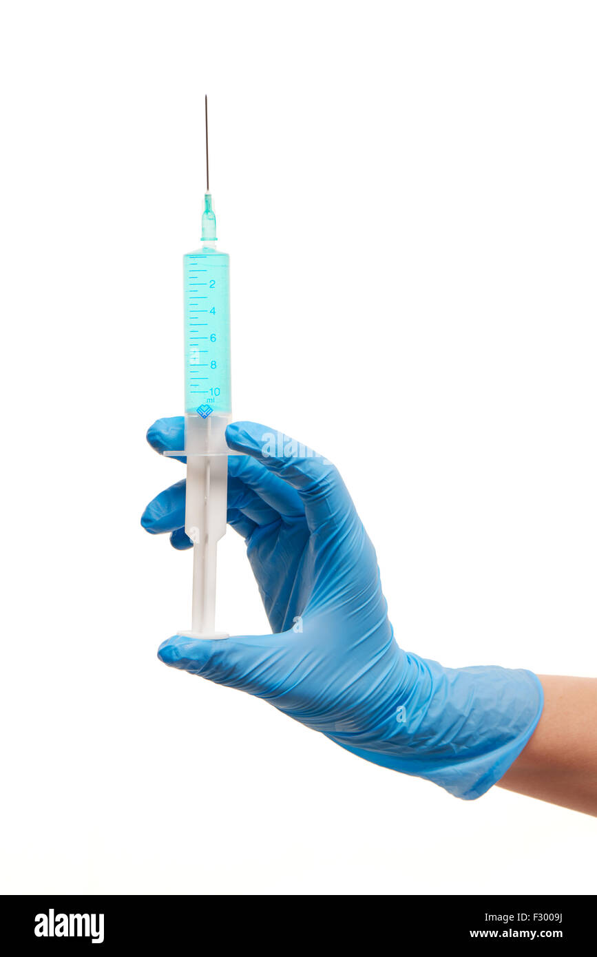 Close up medico donna la mano in blu sterilizzato guanto chirurgico con plastica medical siringa riempita di farmaco blu contro wh Foto Stock