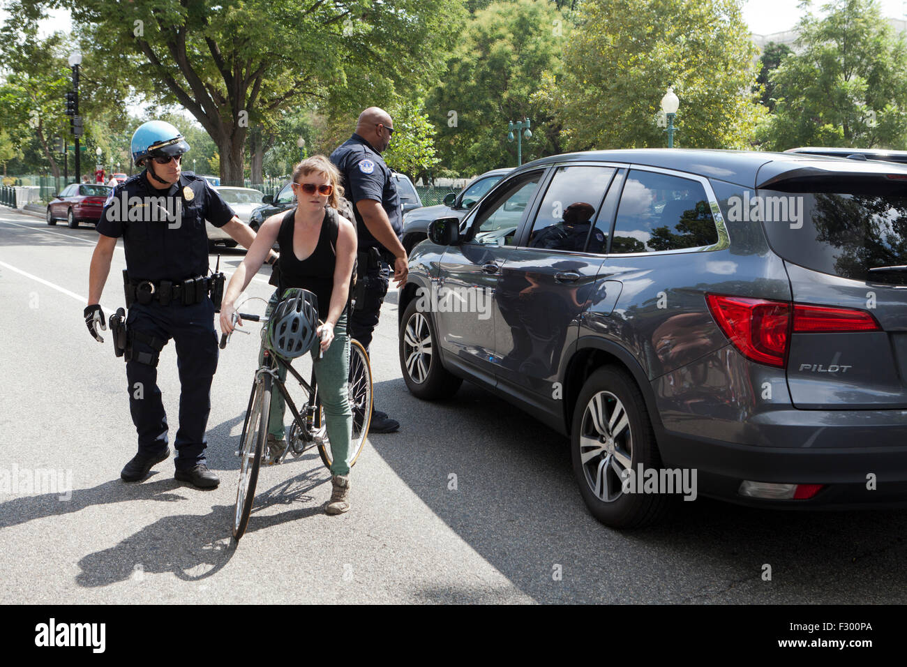 Funzionario di polizia rompendo un alterco tra il guidatore e il ciclista - Washington DC, Stati Uniti d'America Foto Stock