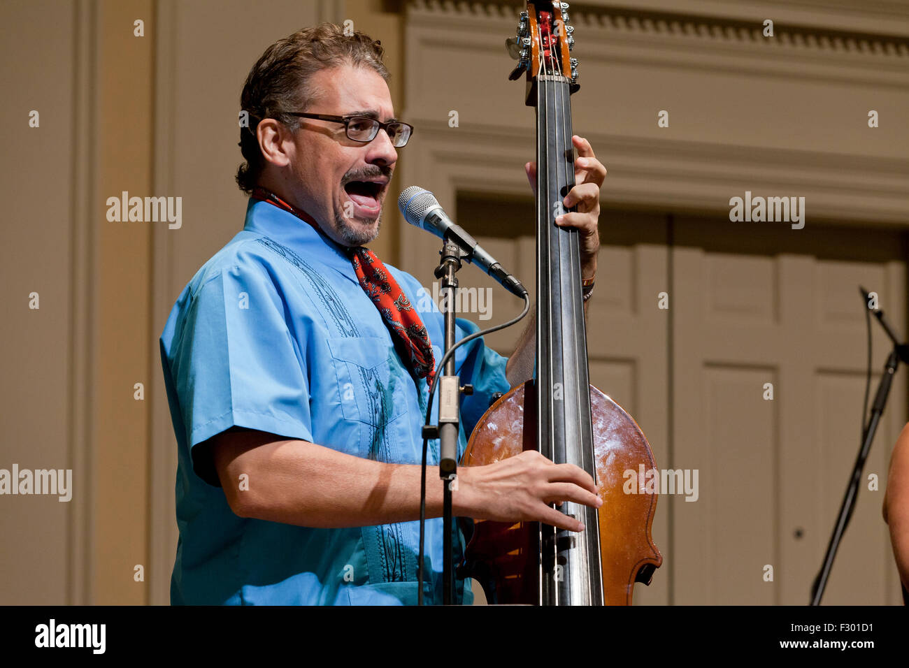 Uomo di cantare e suonare montante elettrico strumento basso sul palco - USA Foto Stock