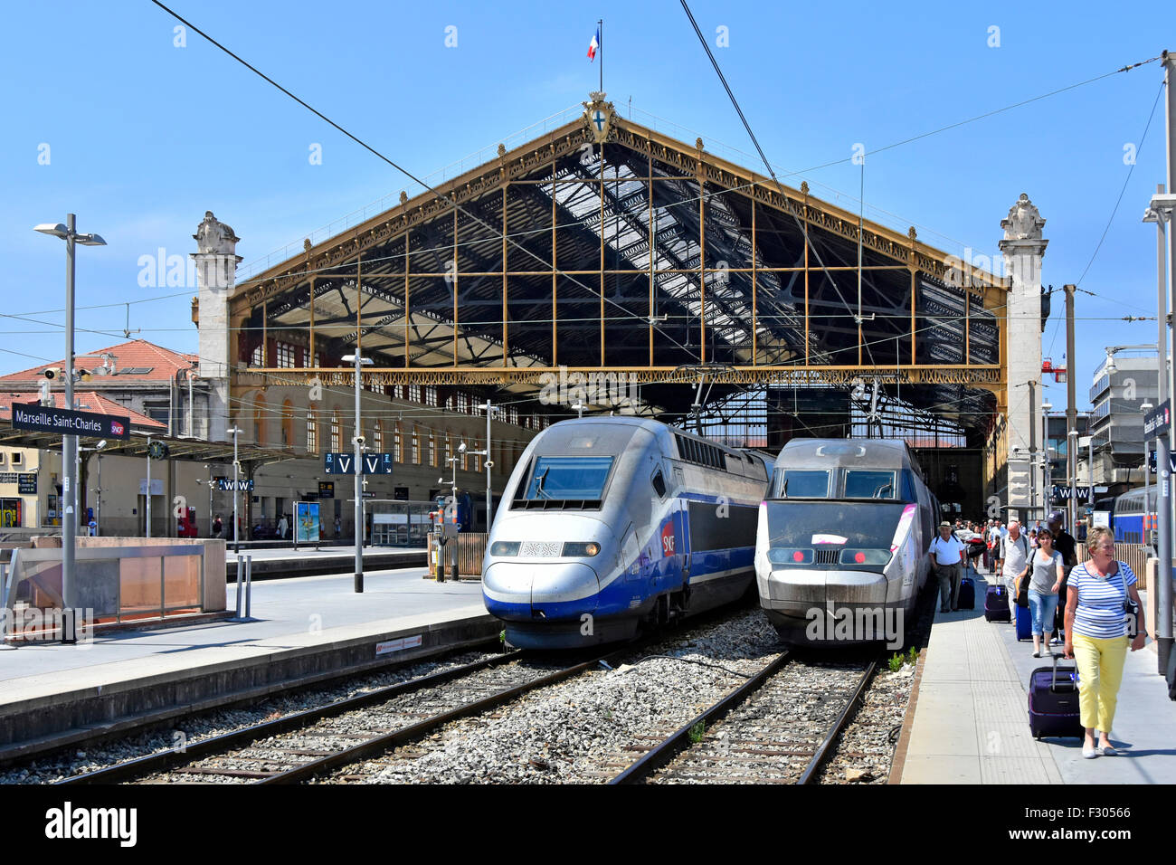 Trasporto ferroviario in Francia treni ad alta velocità SNCF TGV alla stazione ferroviaria francese Marseille saint charles con passeggeri sulla piattaforma estate cielo blu giorno Foto Stock