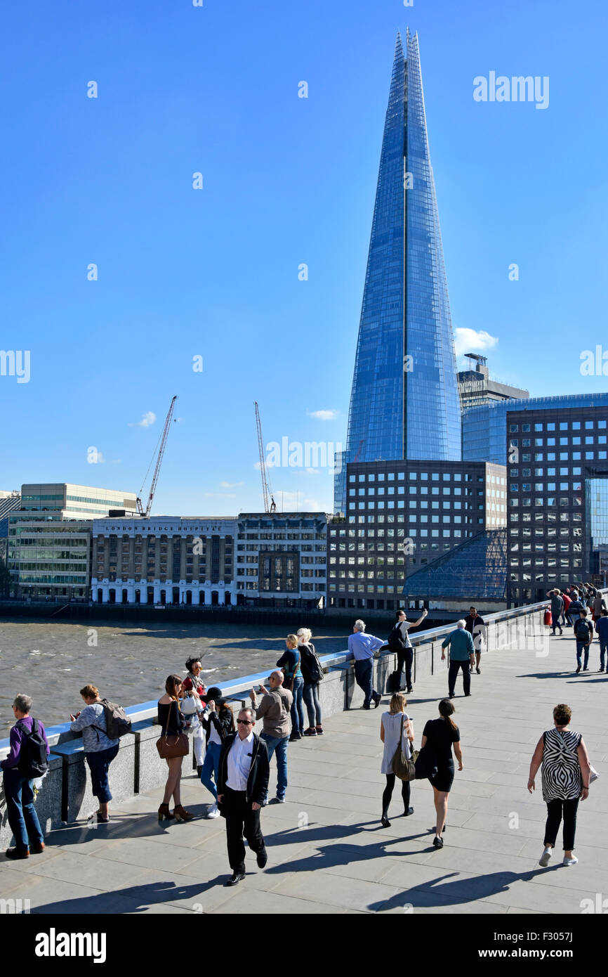 Ponte di Londra persone che attraversano il Tamigi con il simbolo del grattacielo Shard oltre a Southwark Inghilterra Regno Unito Foto Stock