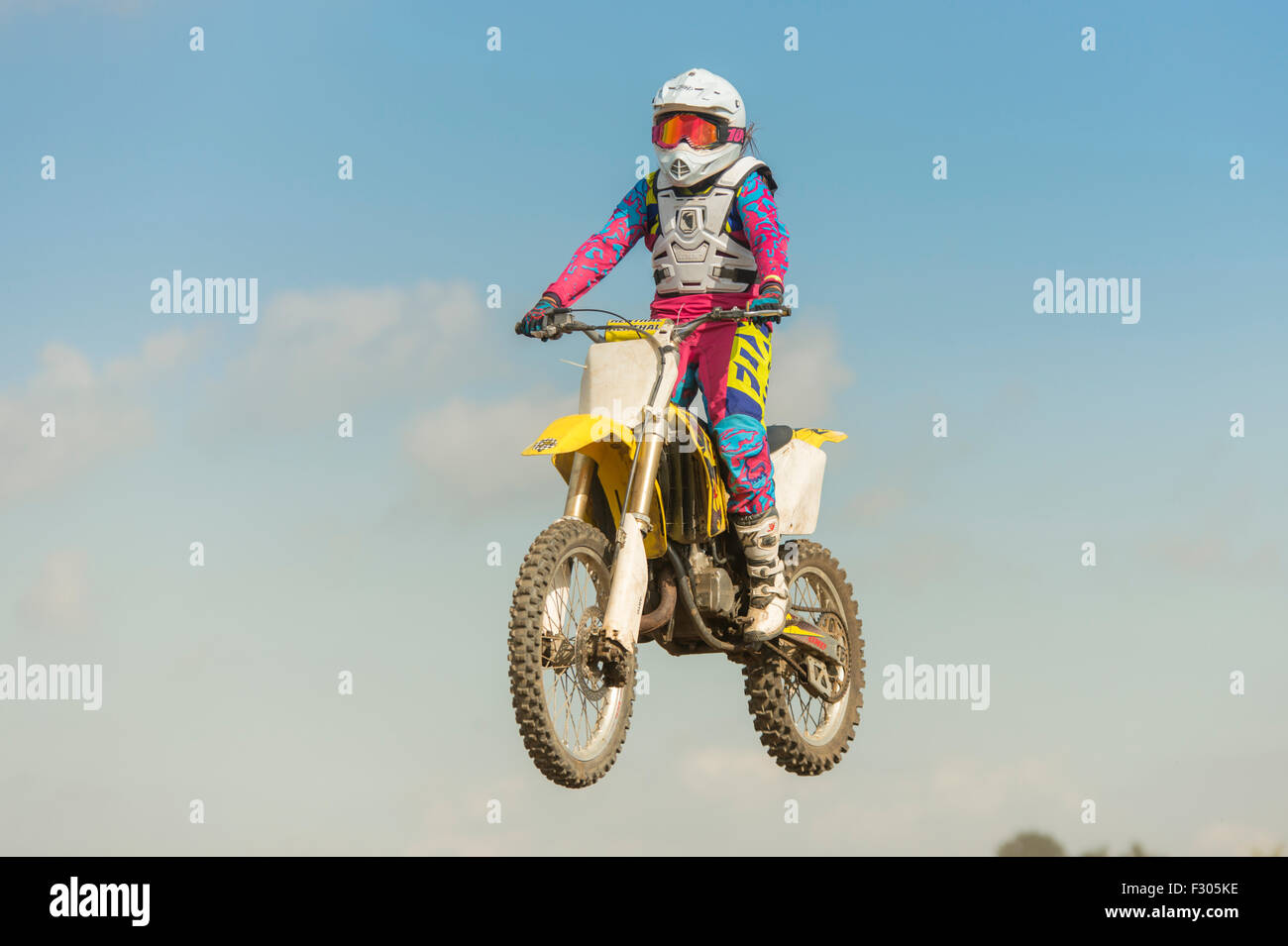 Motocross femminile rider jumping contro un cielo blu sullo sfondo Foto Stock