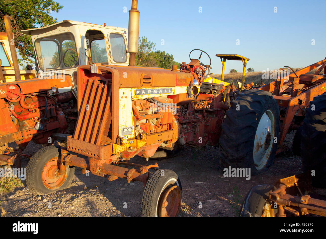 Arrugginito trattore agricolo in junkyard al tramonto,US,2015. Foto Stock