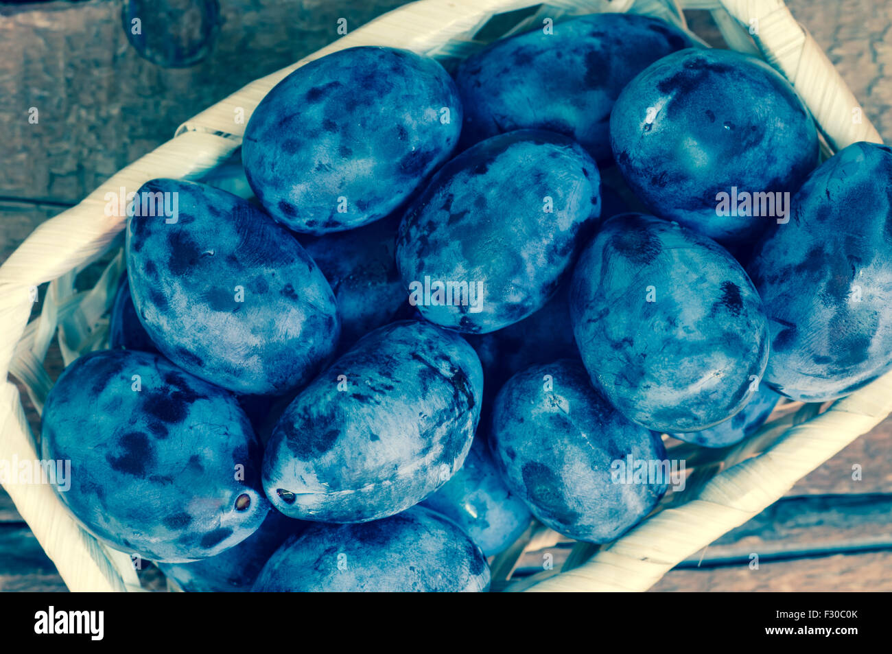 Freschi colori blu le prugne in un cesto di vimini vista superiore Foto Stock