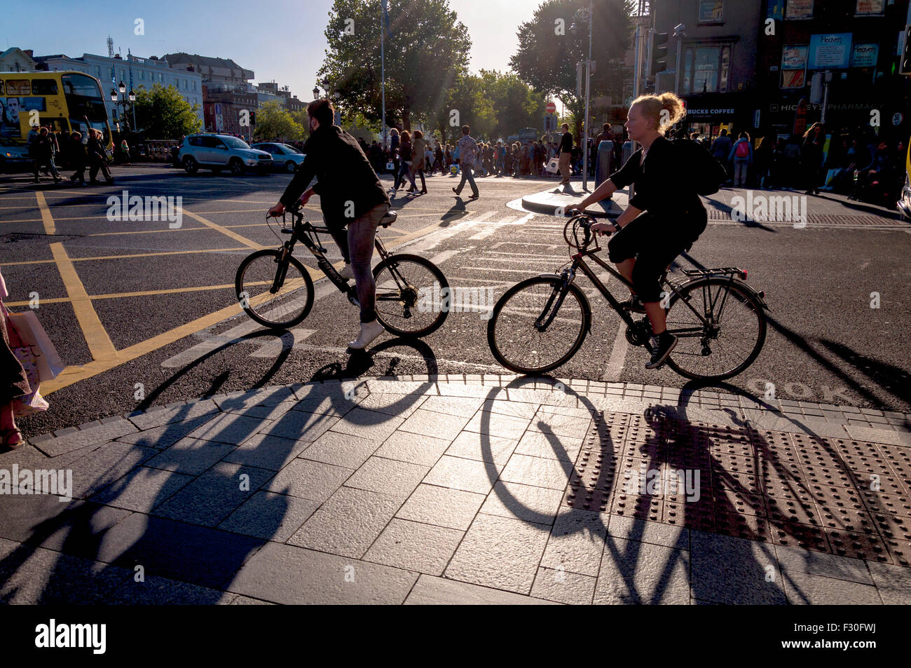 Tempo Dublino Irlanda. Ciclisti e pedoni nel centro della città in un caldo sabato pomeriggio soleggiato. Foto Stock