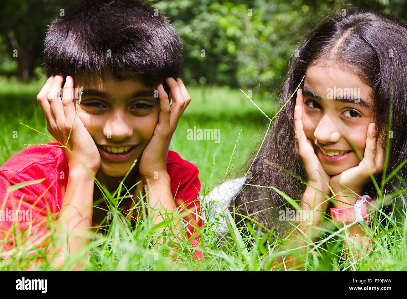 Capelli neri Black-capelli Carefree abiti casual allegria mento sul lato mento sulle mani Close Up Closeup fiducioso destinazioni gomiti esilarante femmine femmina testa e spalle vacanze indulgenza indulgente indulgere a stili di vita che giace disteso sulla parte anteriore fuori Foto Stock