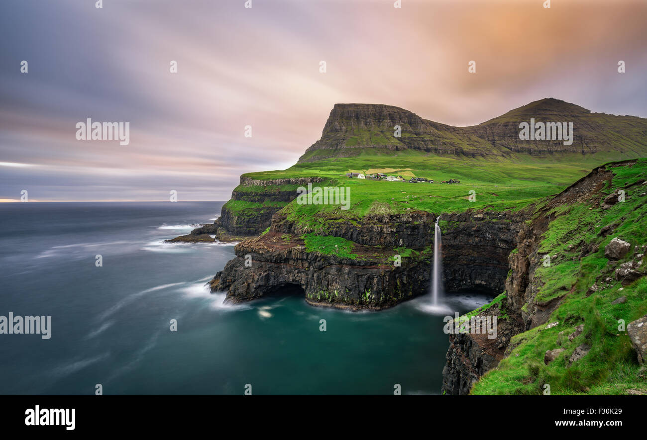 Gasadalur villaggio e la sua leggendaria cascata, funzionario ministeriale, Isole Faerøer, Danimarca. Lunga esposizione. Foto Stock