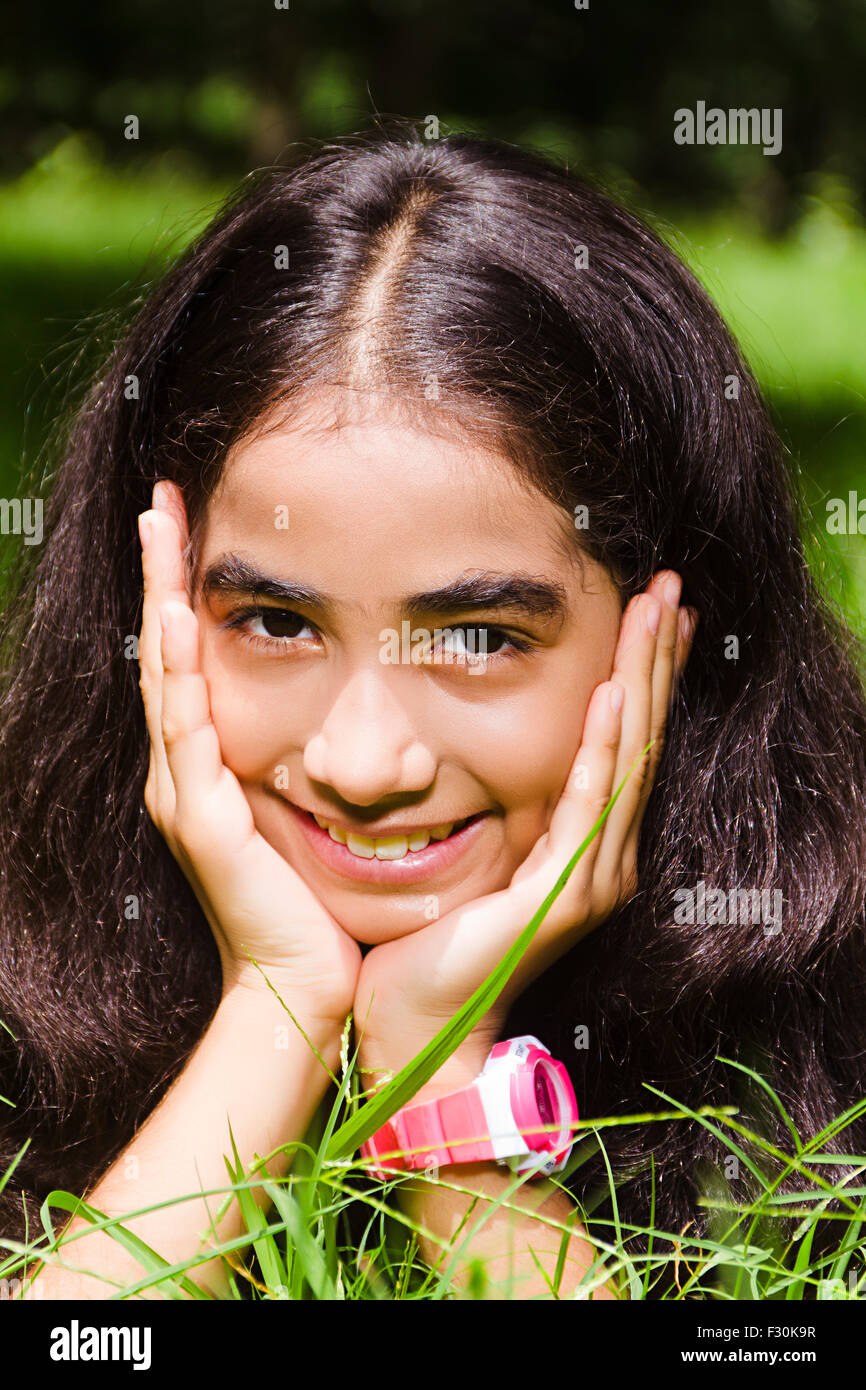 Capelli neri; nero-capelli; un abbigliamento sportivo; abiti casual; infanzia; mento sulla mano; mento sulle mani; Closeup; godendo; GIARDINAGGIO; le mani sul mento; la testa e la spalla; indulgere; innocenza; Stili di vita; un popolo; una persona; una sola persona; giocoso giocando; Gioco Foto Stock