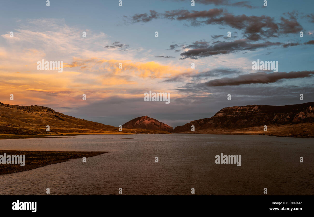 Il fiume Shoshone e il serbatoio al crepuscolo e fiancheggiata da robuste, aride banche di alta montagna e con colorati sky. Foto Stock