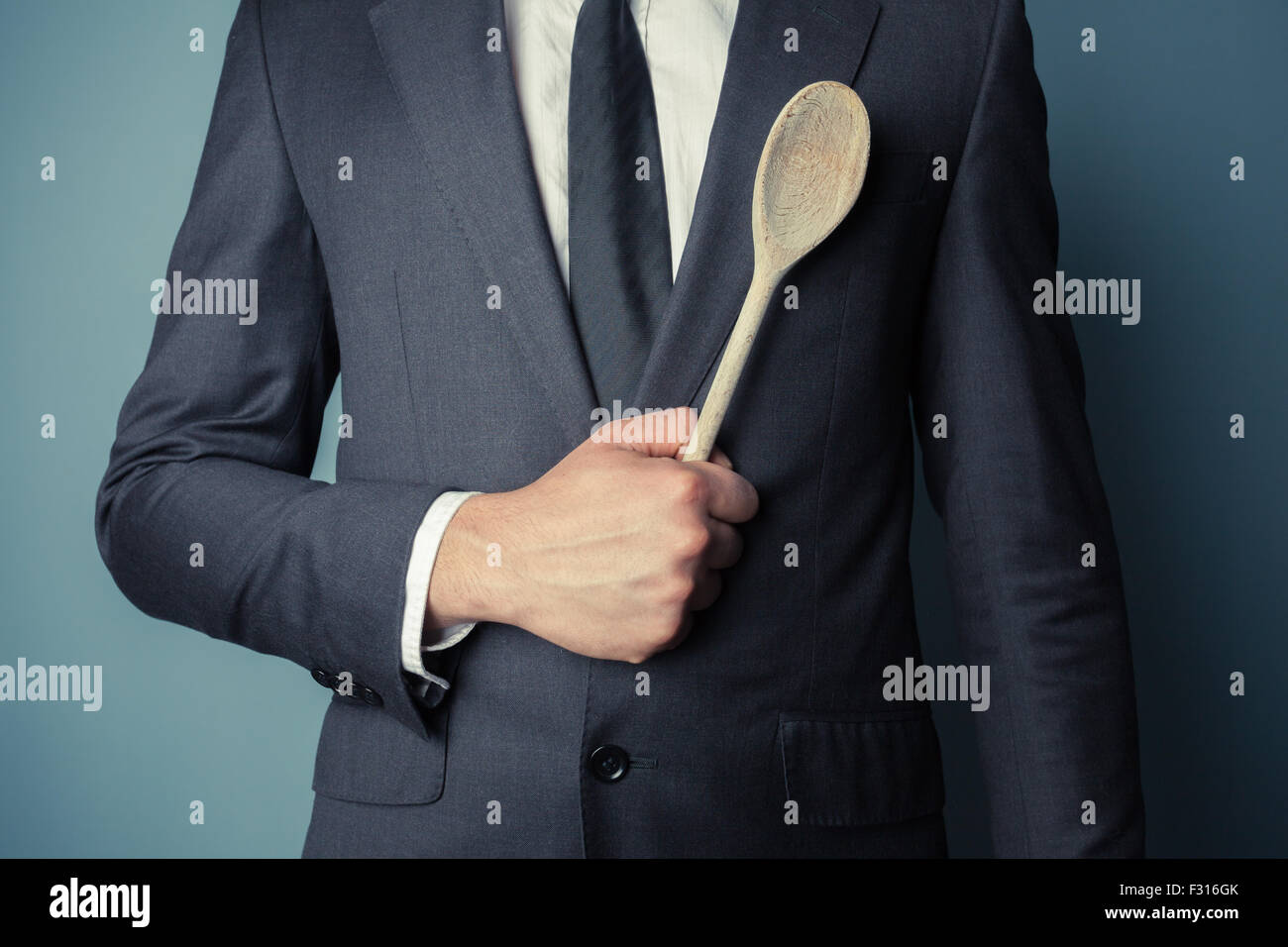 Giovane imprenditore è in possesso di un cucchiaio di legno Foto Stock