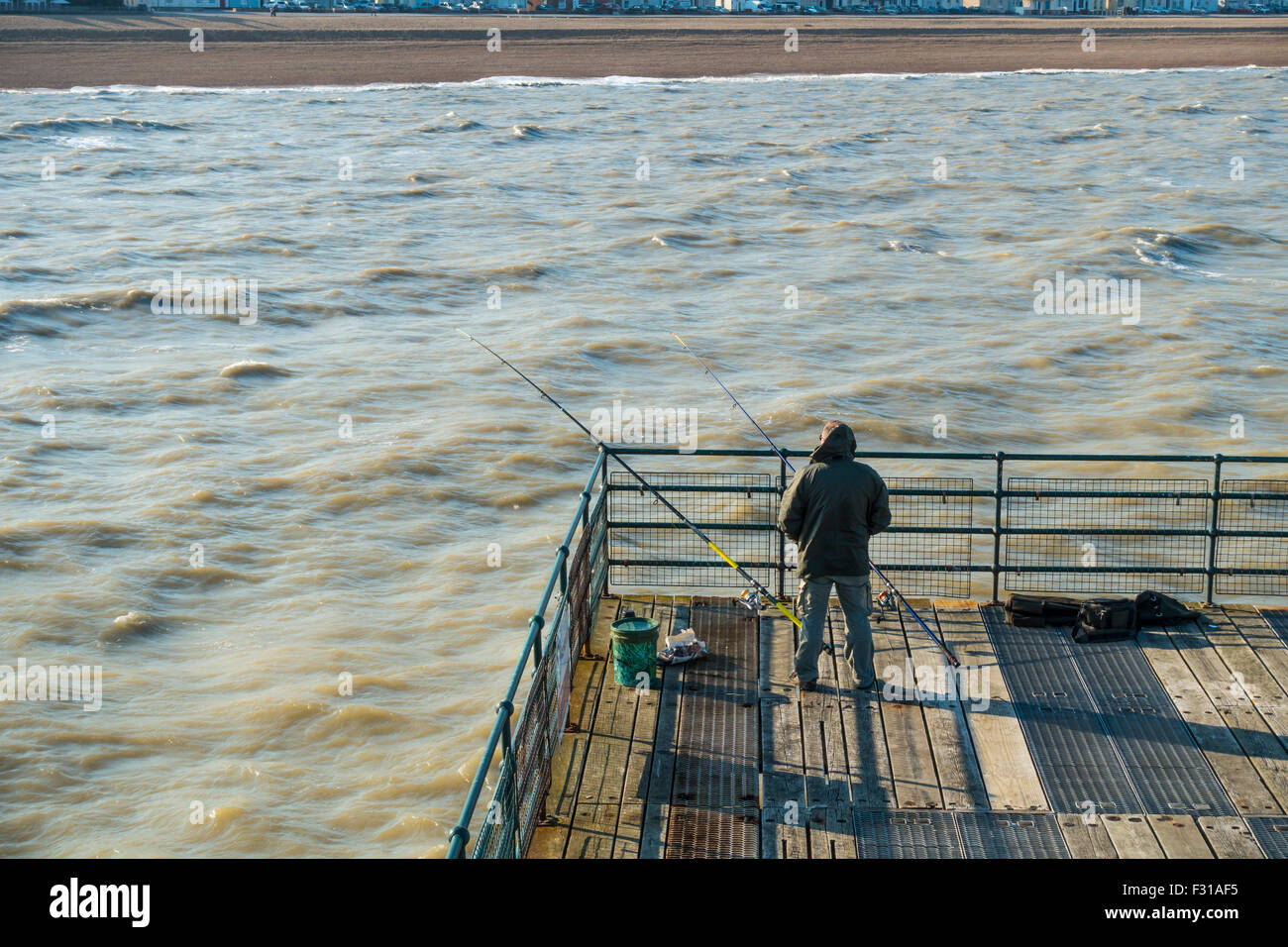 La pesca in mare pescatore pescatore trattare Pier Deal Kent England Regno Unito Foto Stock
