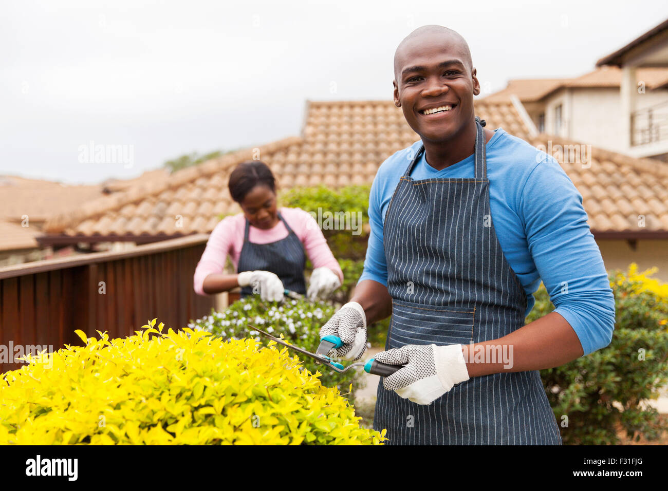 Bello l'uomo africano giardinaggio con sua moglie a casa Foto Stock