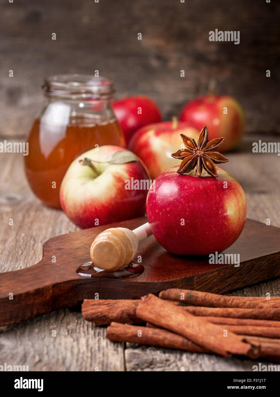 Mele, miele, cannella, anice stellato su uno sfondo di legno Foto Stock