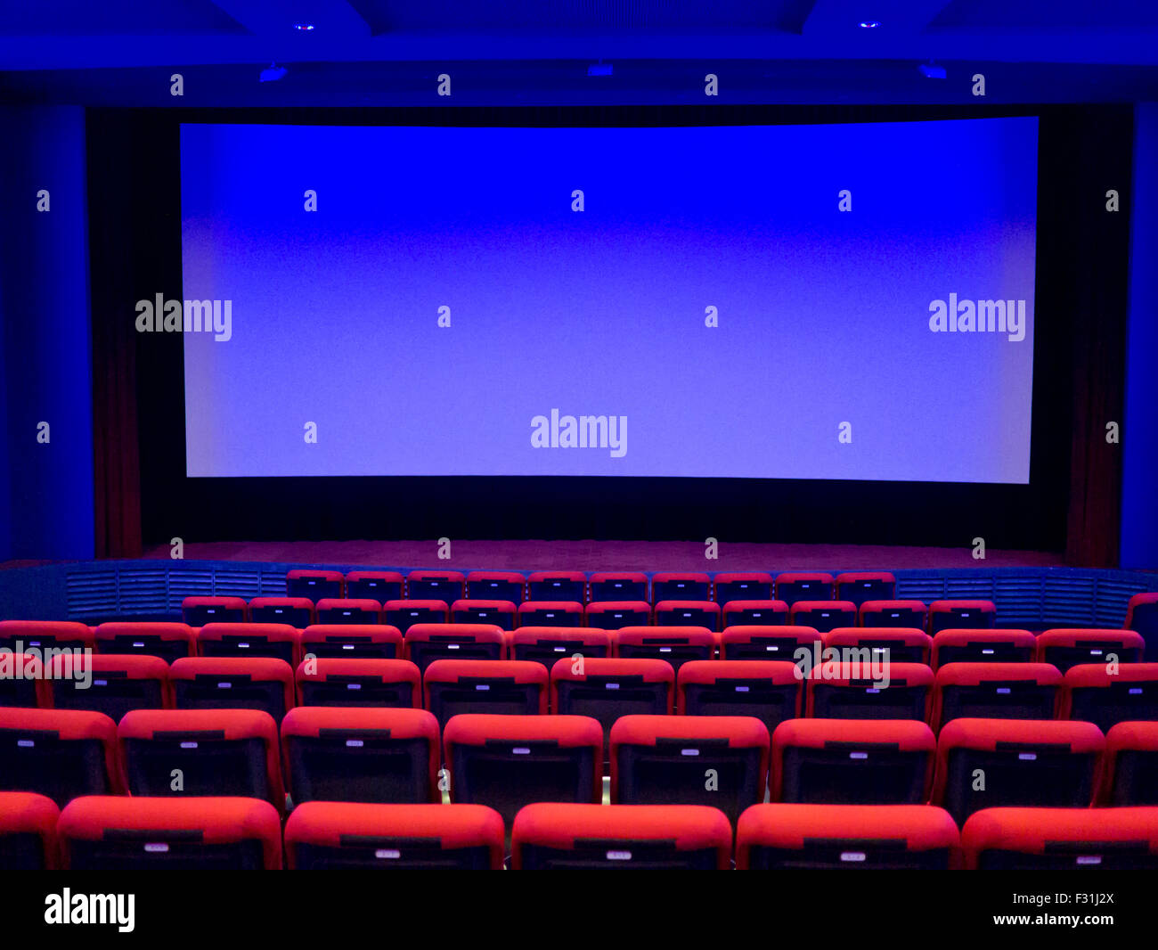 Svuotare il cinema auditorium. Schermo di proiezione è pronto per l'aggiunta di una foto Foto Stock