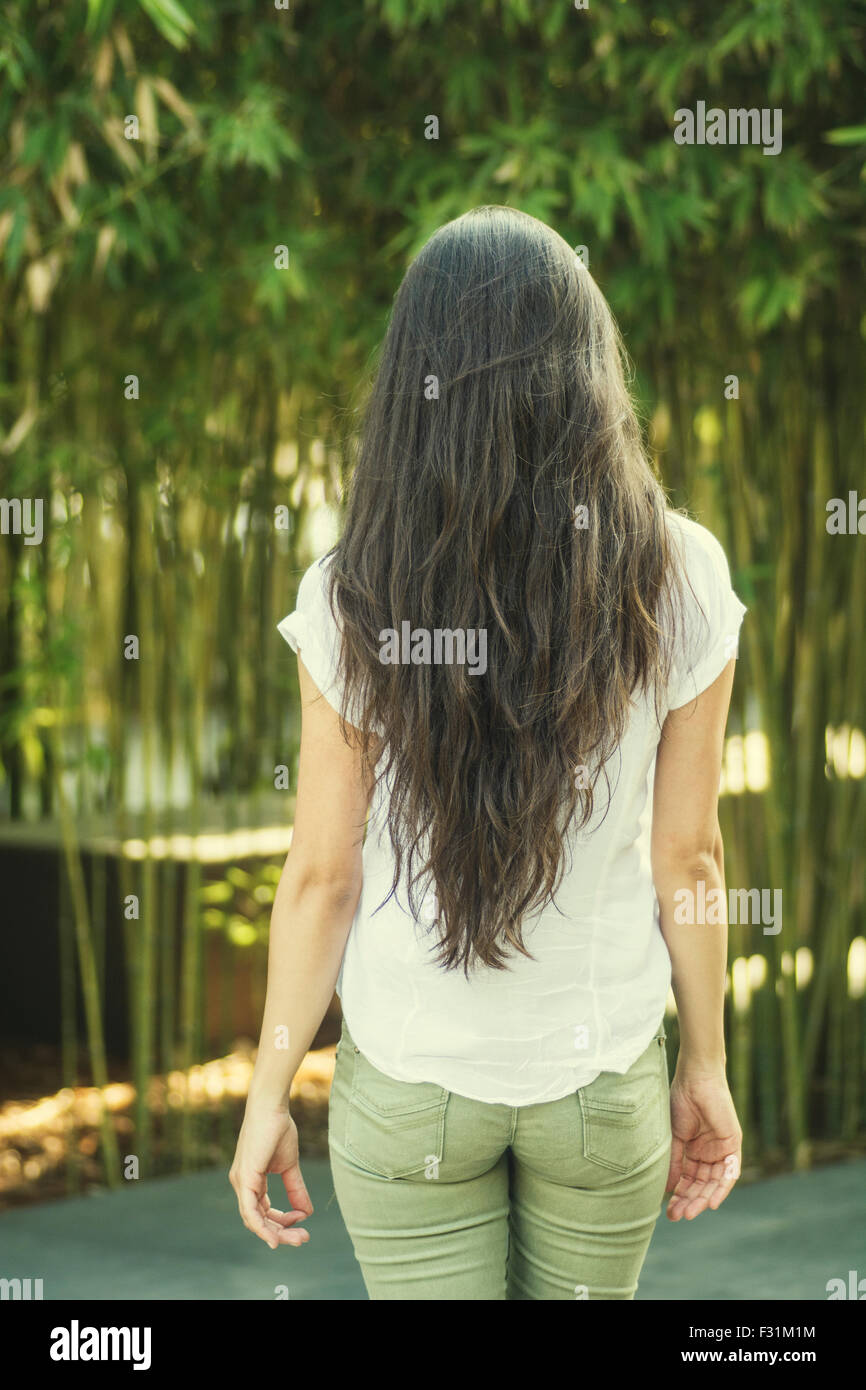 Donna con belle lunghi capelli scuri in piedi all'aperto Foto Stock