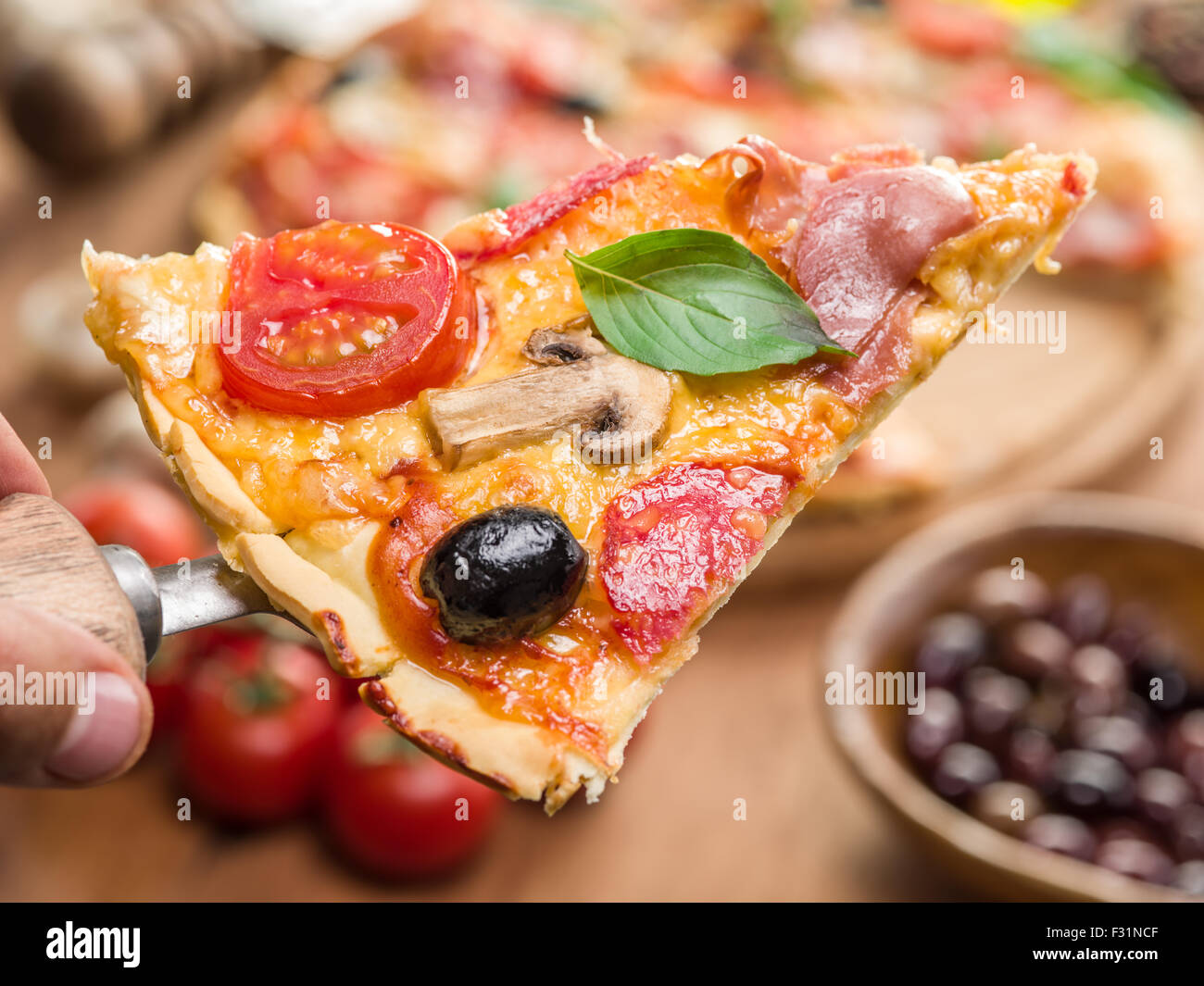 Pezzi di pizza con funghi, prosciutto e pomodori. Vista dall'alto. Foto Stock
