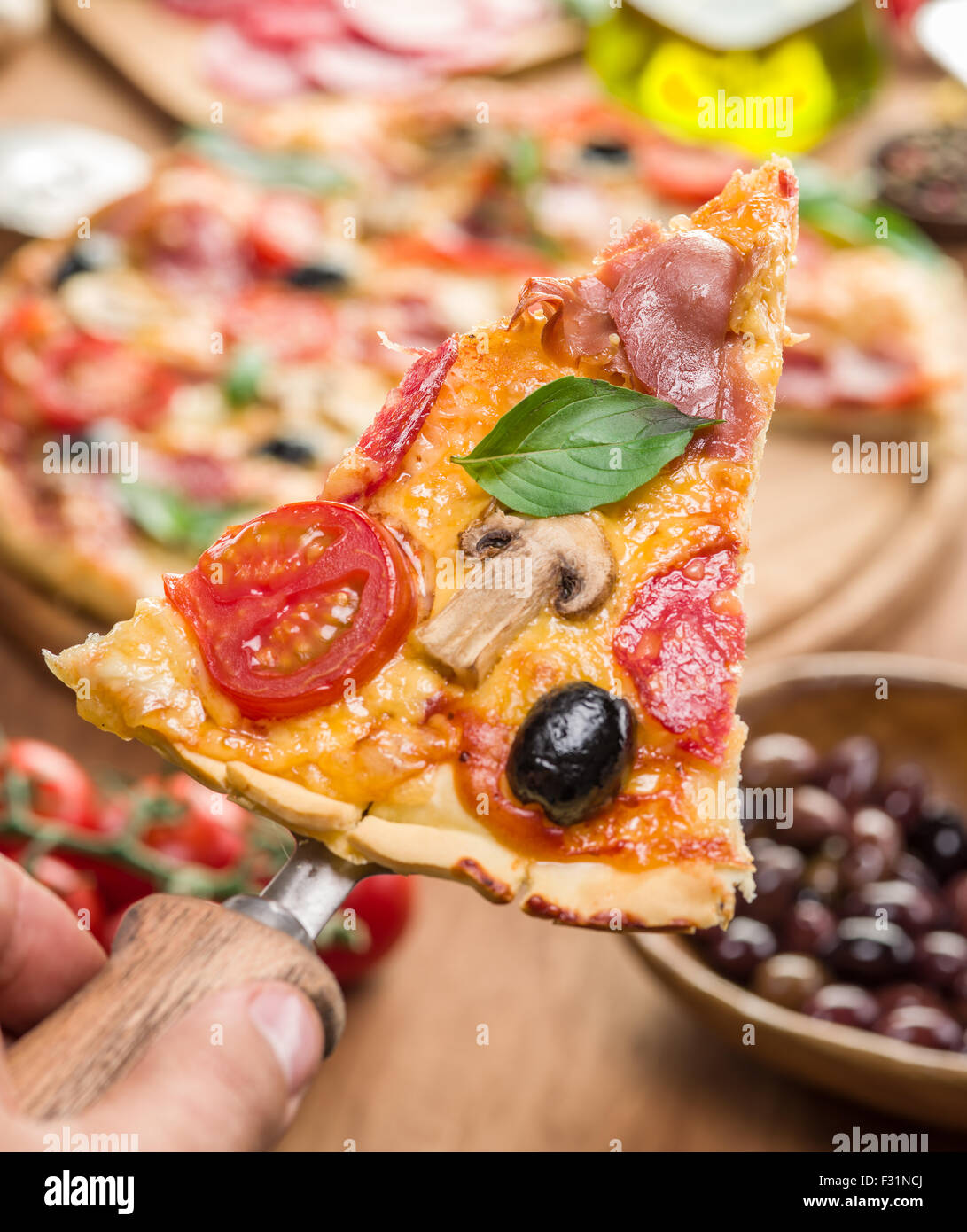 Pezzi di pizza con funghi, prosciutto e pomodori. Vista dall'alto. Foto Stock