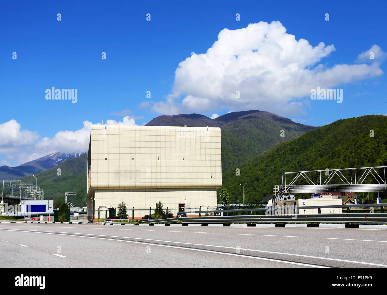 Autostrada passando attraverso il villaggio su uno sfondo di montagne Foto Stock