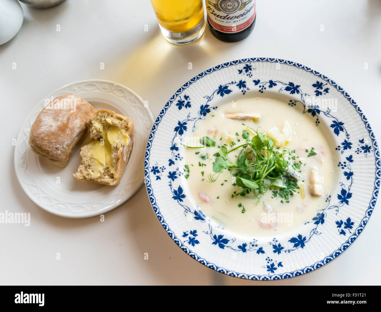 Café pranzo una ciotola di eglefino Chowder servita con un marrone imburrato pane Foto Stock